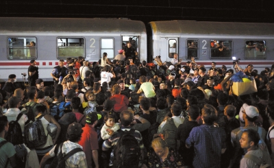 9月19日，在克罗地亚的托瓦尔尼克火车站，难民们试图挤上火车。新华社发