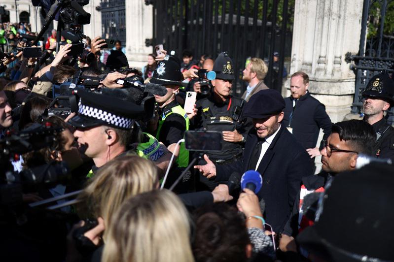 贝克汉（右前方戴帽者）排队瞻仰女王仪容，仍引起媒体骚动。（路透）